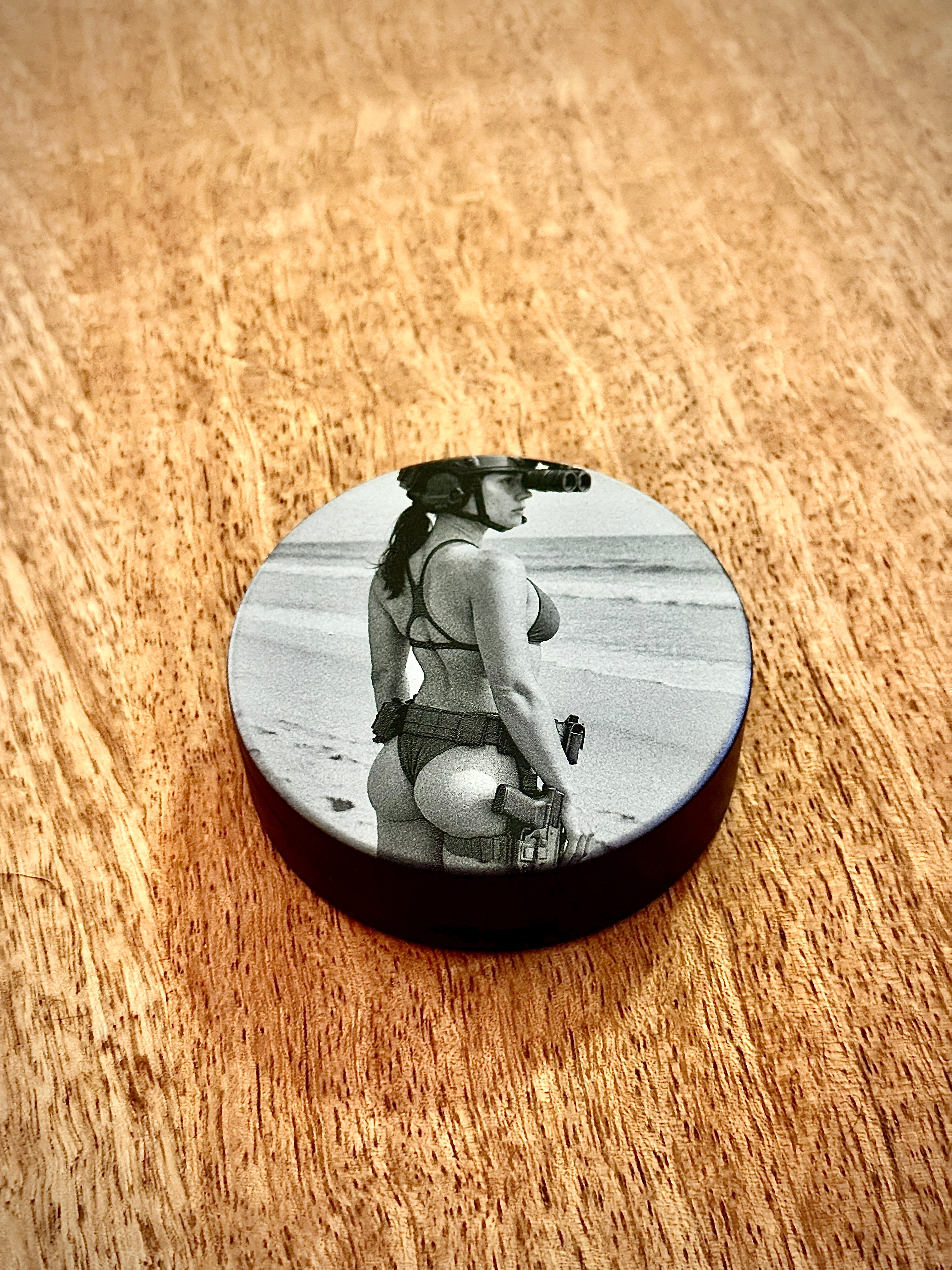 Metal Zyn Can for nicotine pouches with engraved design of "pin-up" style woman in a. bikini and tactical gear. With integrated bottle opener. 