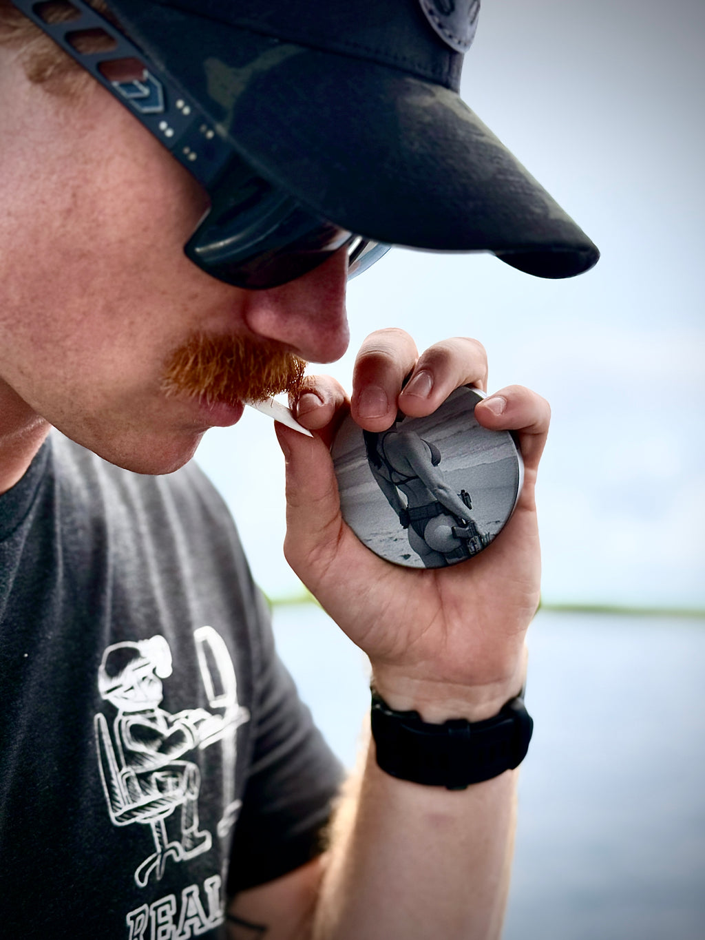 Metal Zyn Can for nicotine pouches with engraved design of "pin-up" style woman in a. bikini and tactical gear. With integrated bottle opener. shown being used by military style man.