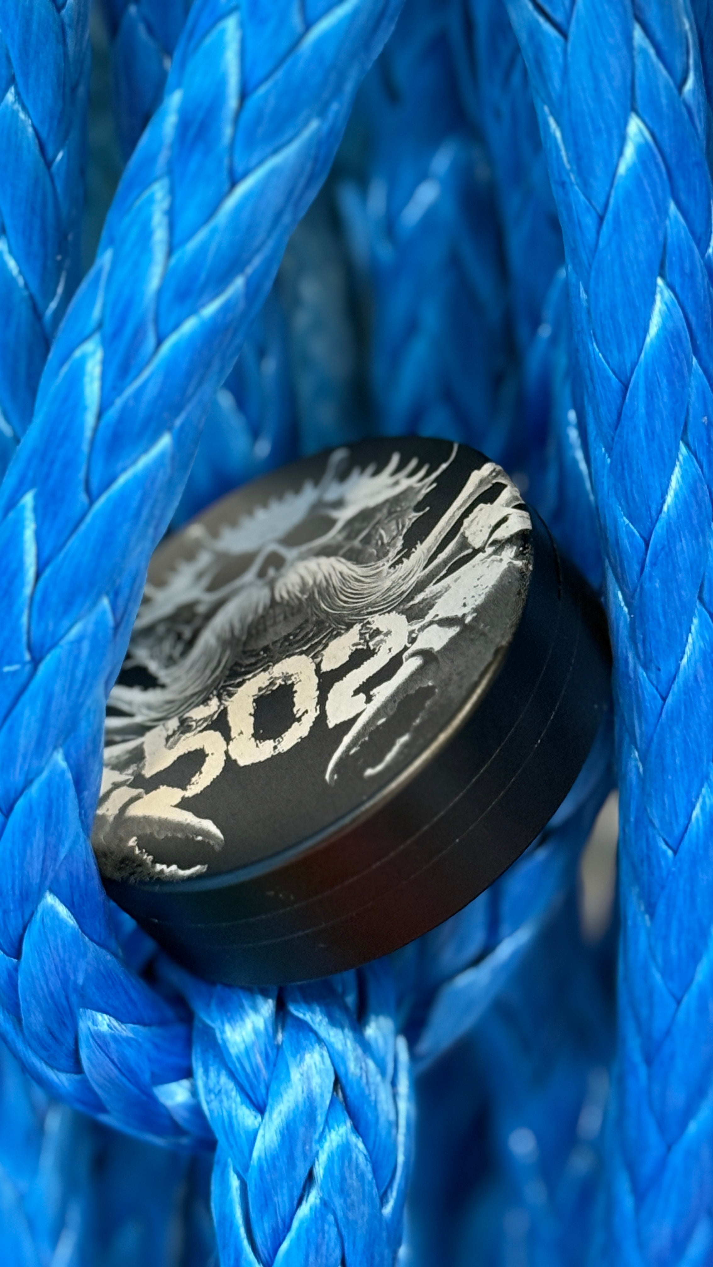 Metal Zyn Can for nicotine pouches with custom engravings. With integrated bottle opener. displayed on blue rope.