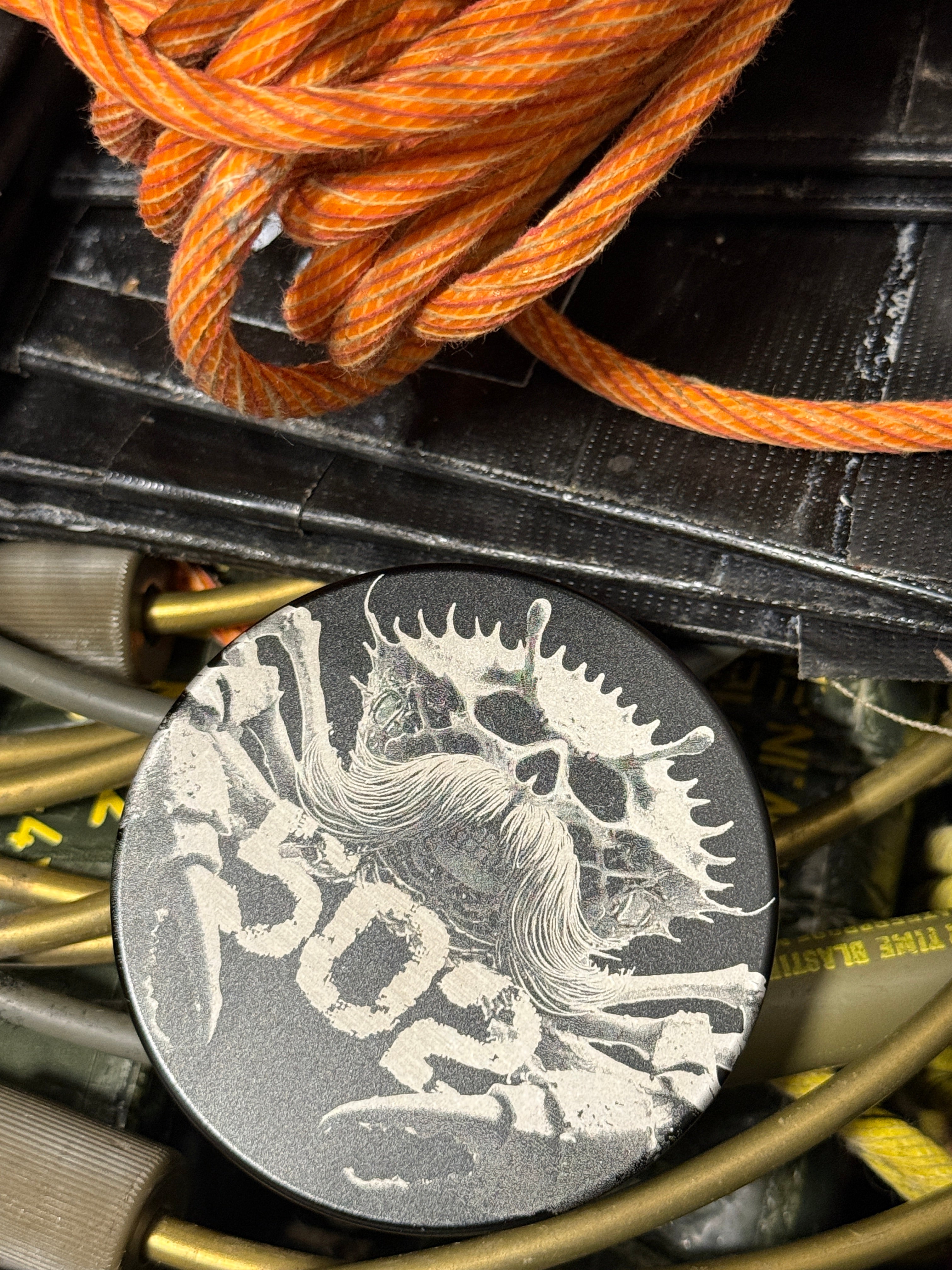 Metal Zyn Can for nicotine pouches with custom engravings. With integrated bottle opener. Displayed on Tactical equipment.