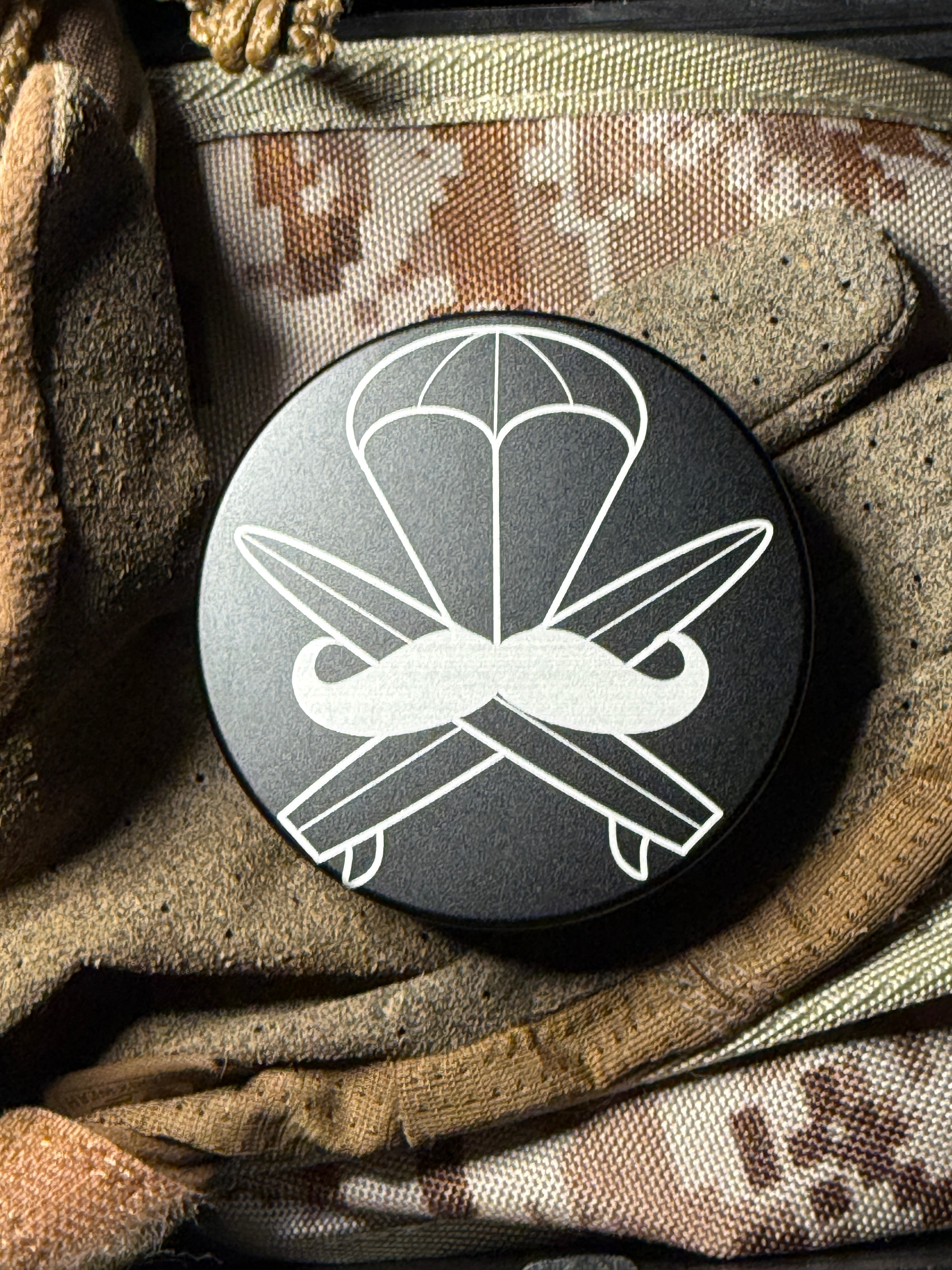 Metal Zyn Can for nicotine pouches with engraved design with integrated bottle opener. Displayed on military gear.