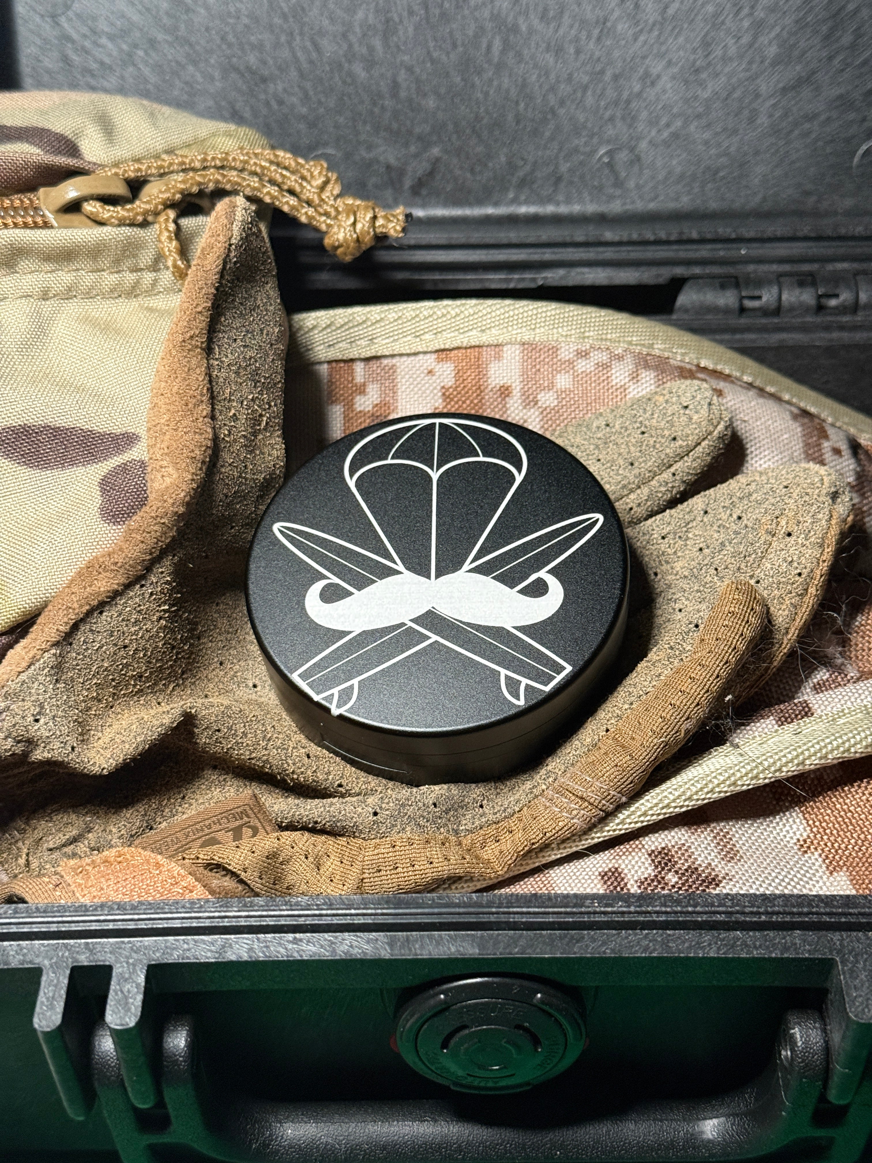 Metal Zyn Can for nicotine pouches with engraved design with integrated bottle opener. Displayed on military gear