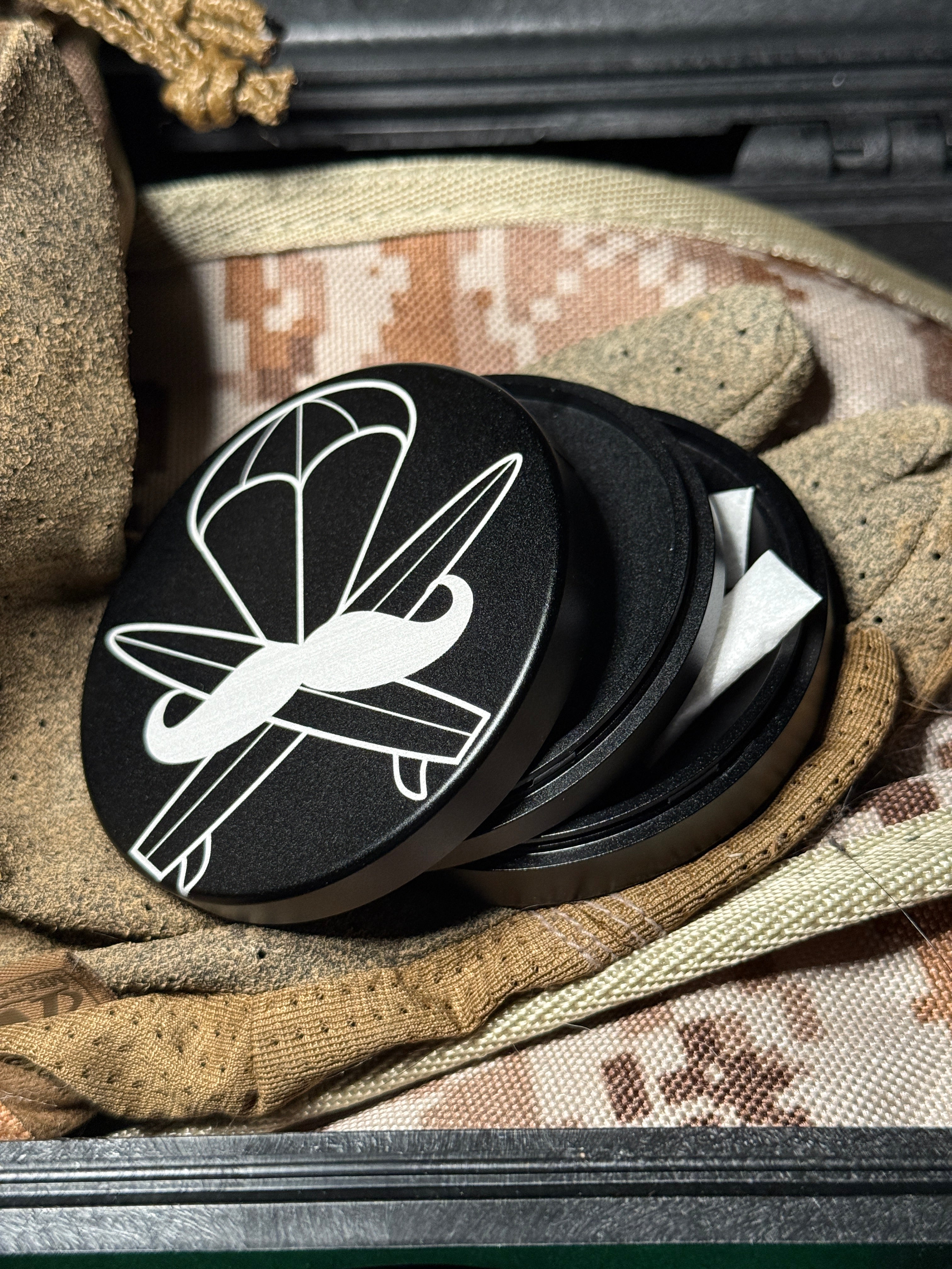 Metal Zyn Can for nicotine pouches with engraved design with integrated bottle opener. Displayed on military gear.