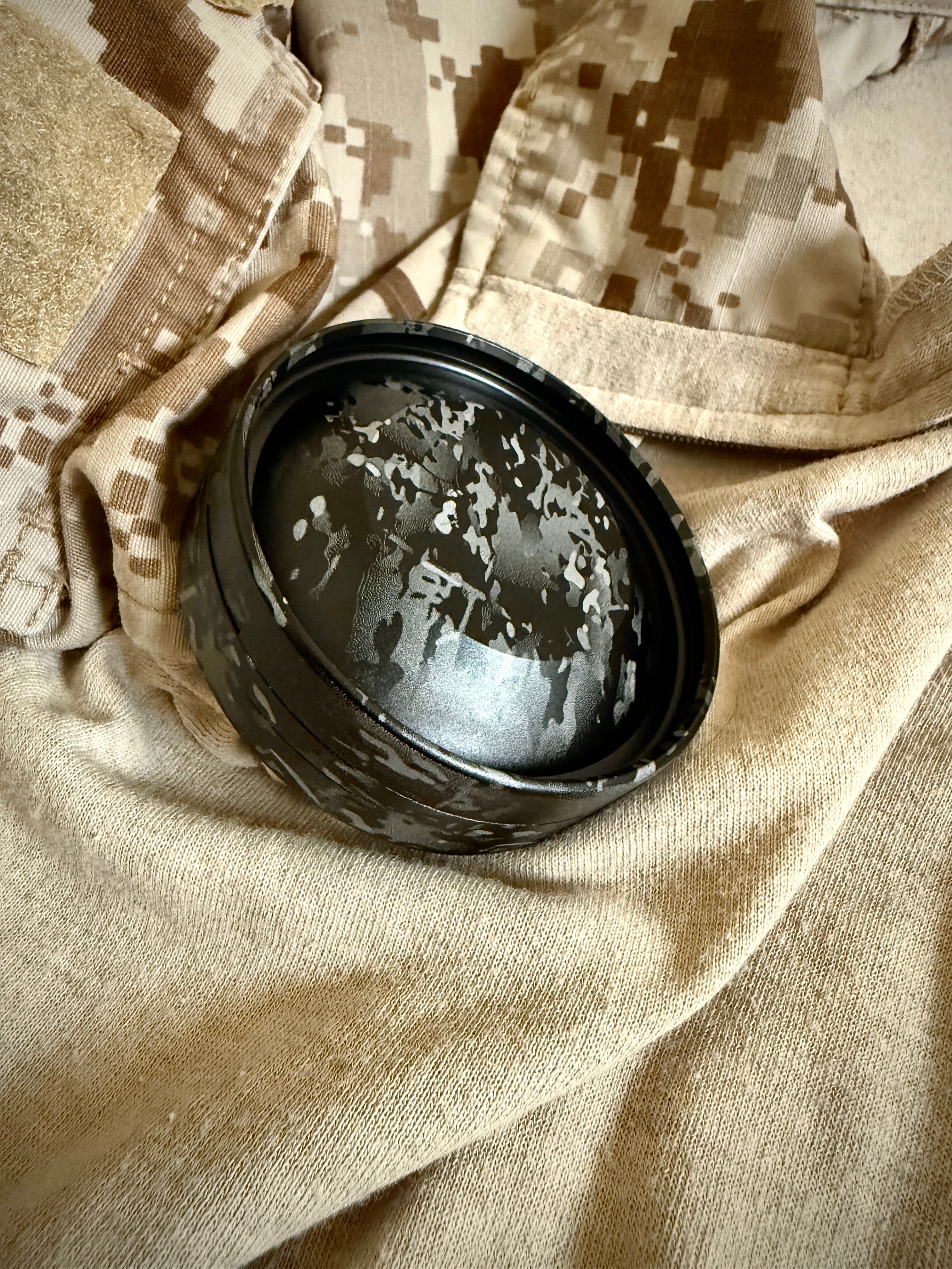 Metal Zyn Can for nicotine pouches completely engraved with camouflage design. With integrated bottle opener. Displayed on crye camouflage uniform.