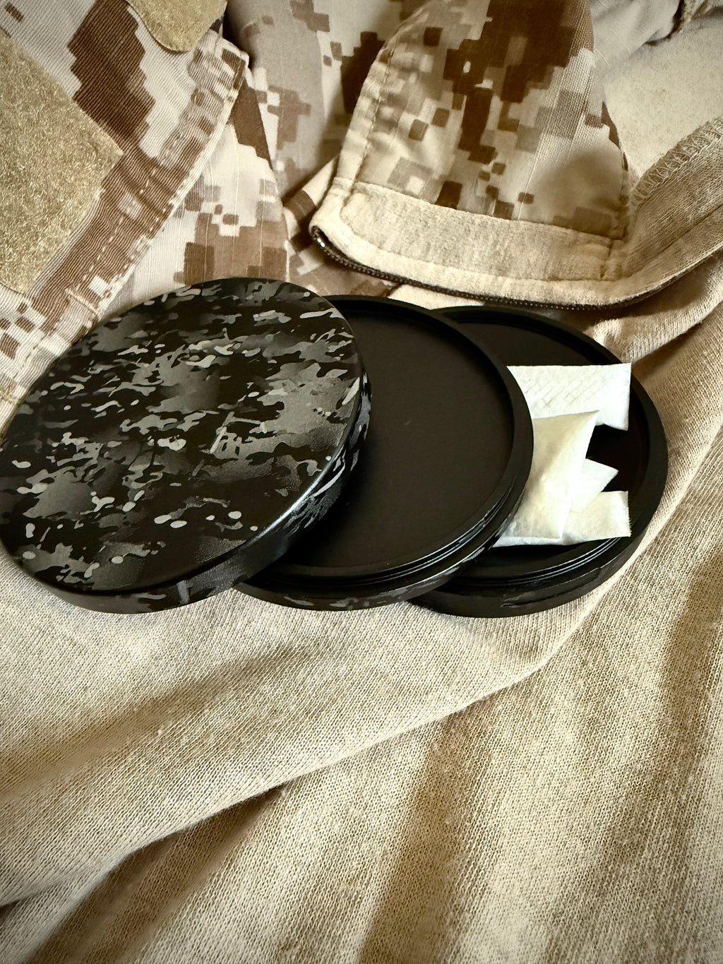 Metal Zyn Can for nicotine pouches completely engraved with camouflage design. With integrated bottle opener. Displayed on crye camouflage uniform.