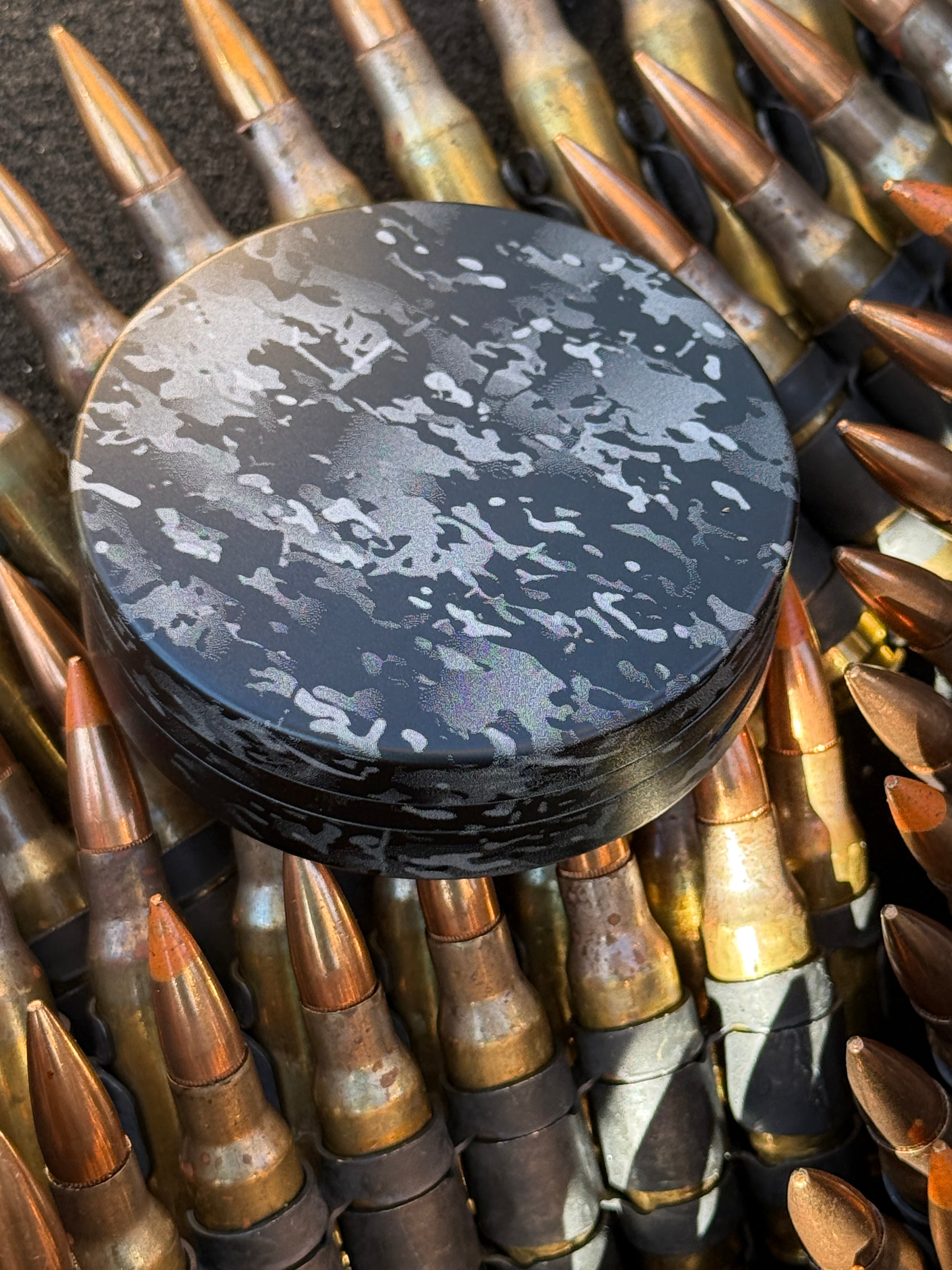 Metal Zyn Can for nicotine pouches completely engraved with camouflage design. With integrated bottle opener. Displayed on brass.