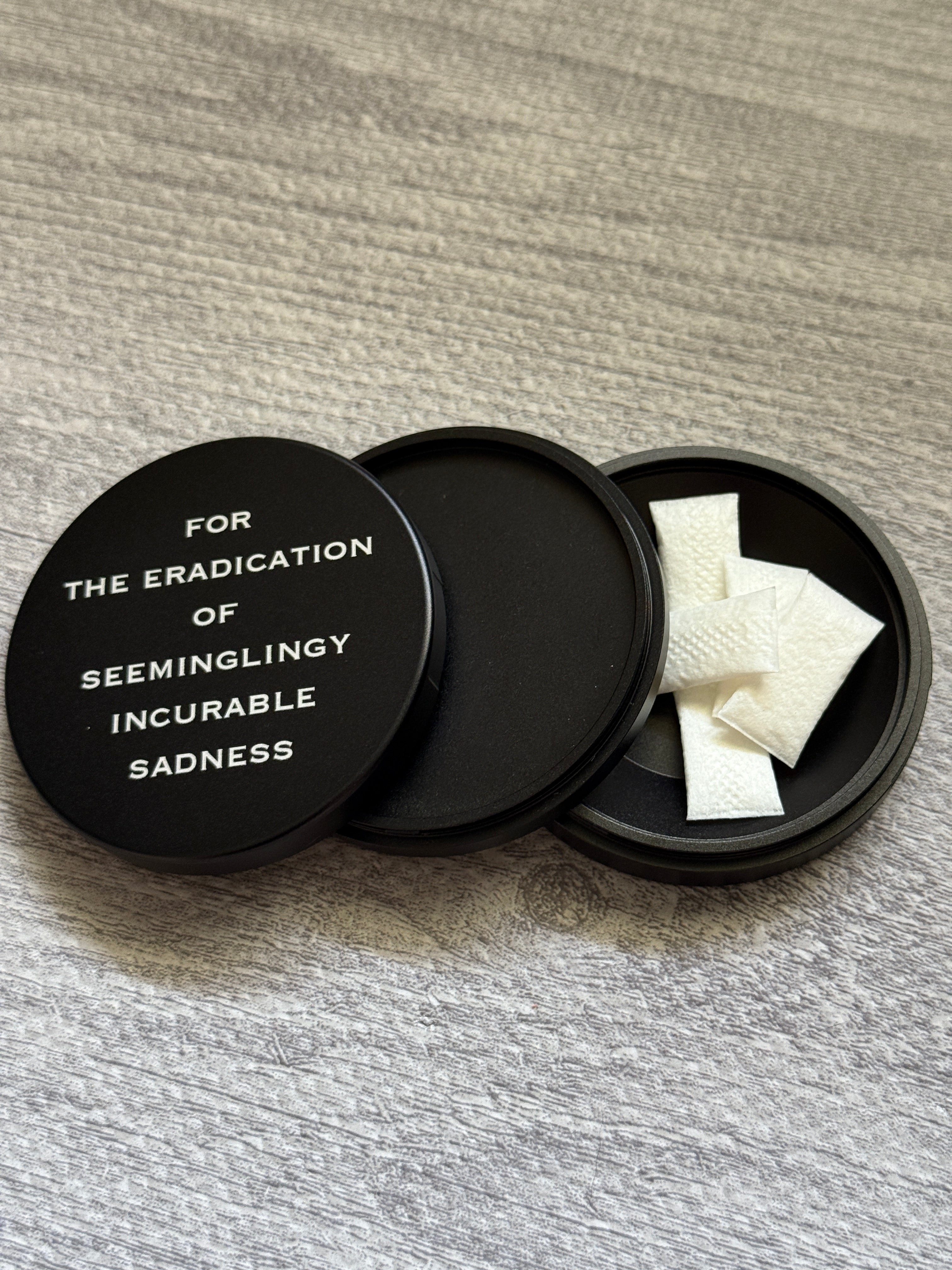 Metal Zyn Can for nicotine pouches with engraved design "for the eradication of seemingly incurable sadness". With integrated bottle opener. 